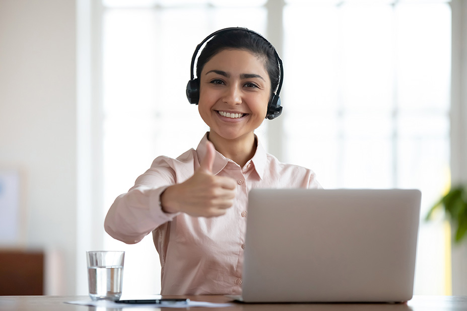 Woman at computer with thumbs up